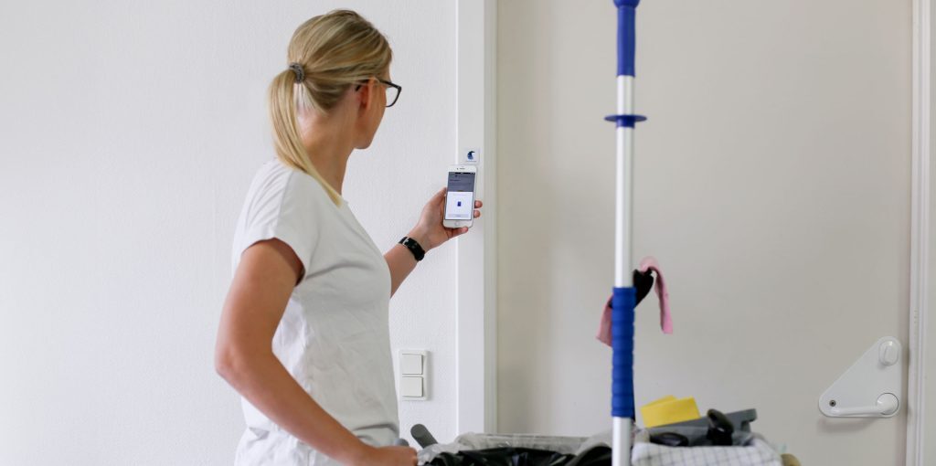 Cleaning staff using their smartphone to scan the CleanManager NFC. 